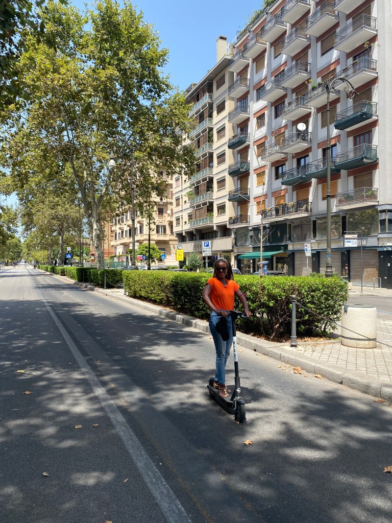 This image has an empty alt attribute; its file name is nneka-on-an-electric-scooter.jpg